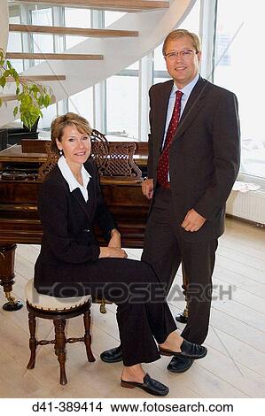 Business couple by grand piano View Large Photo Image Picture - Business couple by grand piano. Fotosearch
