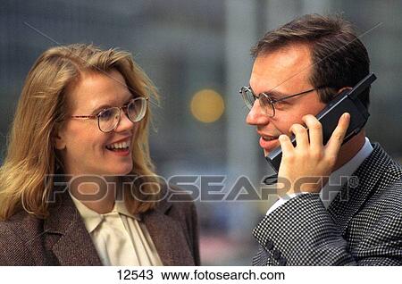 Business couple on city street using cell phone View Large Photo Image Stock Image - Business couple on city street using cell phone. Fotosearch