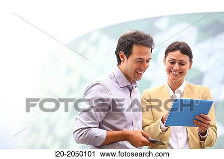 Business man and business woman with tablet and smartphone in business center. San Sebastian Technology Park. Donostia. Gipuzkoa. Basque Country. Spain. View Large Photo Image Stock Image - Business man and business woman with tablet and smartphone in business center. San Sebastian Technology Park. Donostia. Gipuzkoa. Basque Country. Spain.. Fotosearch
