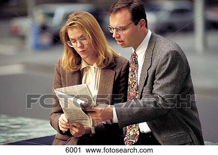 Business man and woman reading newspaper View Large Photo Image Stock Image - Business man and woman reading newspaper. Fotosearch