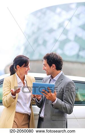 Stock Image - Business man and woman with tablet in parking business center. San Sebastian Technology Park. Donostia. Gipuzkoa. Basque Country. Spain.. Fotosearch