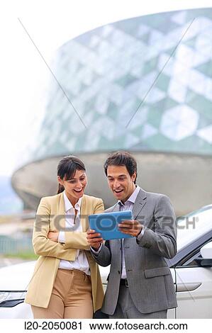 Business man and woman with tablet in parking business center. San Sebastian Technology Park. Donostia. Gipuzkoa. Basque Country. Spain. View Large Photo Image Stock Image - Business man and woman with tablet in parking business center. San Sebastian Technology Park. Donostia. Gipuzkoa. Basque Country. Spain.. Fotosearch