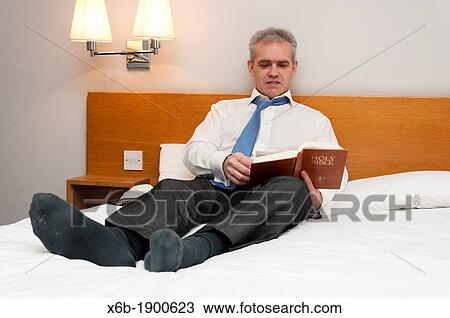 Business man in hotel room reading Holy Bible View Large Photo Image Stock Image - Business man in hotel room reading Holy Bible. Fotosearch