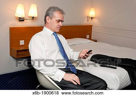 Business man in hotel room using mobile phone View Large Photo Image Stock Photo - Business man in hotel room using mobile phone. Fotosearch