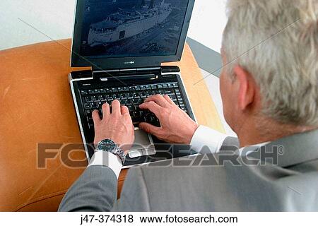 Business man sitting at laptop, hands on keybord, concentrating on the screen View Large Photo Image Stock Photo - Business man sitting at laptop, hands on keybord, concentrating on the screen. Fotosearch