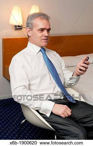 Business man sitting in hotel room in animated conversation View Large Photo Image Stock Image - Business man sitting in hotel room in animated conversation. Fotosearch