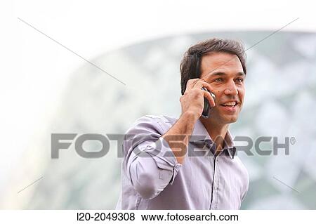 Stock Photo - Business man talking with smartphone in business center. San Sebastian Technology Park. Donostia. Gipuzkoa. Basque Country. Spain.. Fotosearch