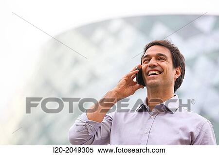 Stock Photography - Business man talking with smartphone in business center. San Sebastian Technology Park. Donostia. Gipuzkoa. Basque Country. Spain.. Fotosearch