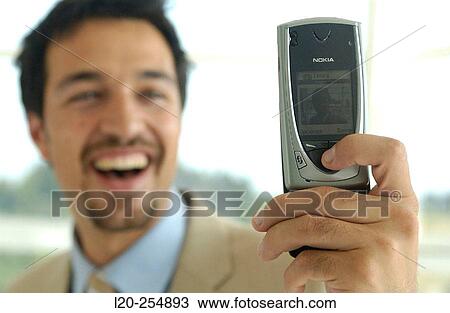 Business man using a cell phone equipped with a digital camera View Large Photo Image Stock Image - Business man using a cell phone equipped with a digital camera. Fotosearch
