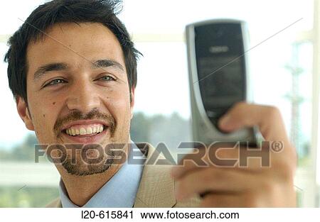 Business man using a cell phone equipped with a digital camera View Large Photo Image Stock Image - Business man using a cell phone equipped with a digital camera. Fotosearch