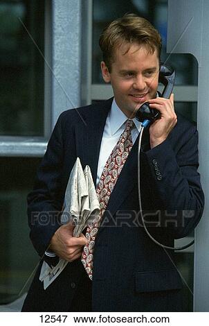 Business man using public telephone View Large Photo Image Stock Photo - Business man using public telephone. Fotosearch