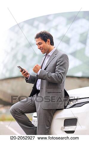 Stock Photo - Business man with smartphone in parking business center. San Sebastian Technology Park. Donostia. Gipuzkoa. Basque Country. Spain.. Fotosearch