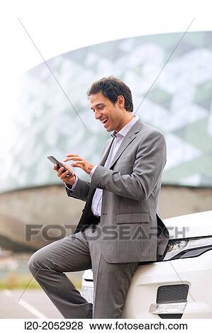 Business man with smartphone in parking business center. San Sebastian Technology Park. Donostia. Gipuzkoa. Basque Country. Spain. View Large Photo Image Stock Photo - Business man with smartphone in parking business center. San Sebastian Technology Park. Donostia. Gipuzkoa. Basque Country. Spain.. Fotosearch