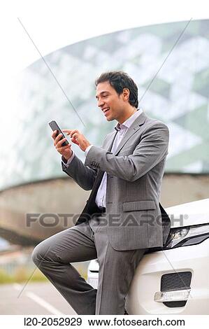 Business man with smartphone in parking business center. San Sebastian Technology Park. Donostia. Gipuzkoa. Basque Country. Spain. View Large Photo Image Stock Photo - Business man with smartphone in parking business center. San Sebastian Technology Park. Donostia. Gipuzkoa. Basque Country. Spain.. Fotosearch