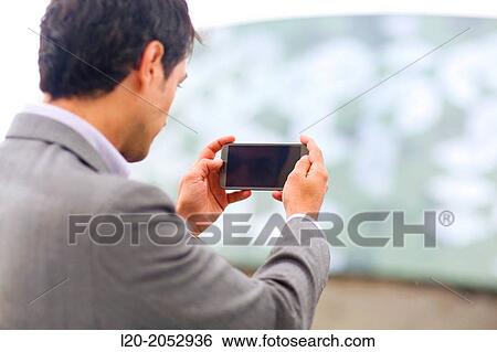 Stock Photograph - Business man with smartphone in parking business center. San Sebastian Technology Park. Donostia. Gipuzkoa. Basque Country. Spain.. Fotosearch