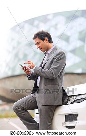 Stock Photography - Business man with smartphone in parking business center. San Sebastian Technology Park. Donostia. Gipuzkoa. Basque Country. Spain.. Fotosearch