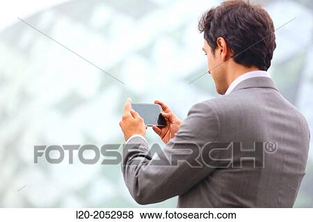 Stock Photo - Business man with smartphone in business center. San Sebastian Technology Park. Donostia. Gipuzkoa. Basque Country. Spain.. Fotosearch