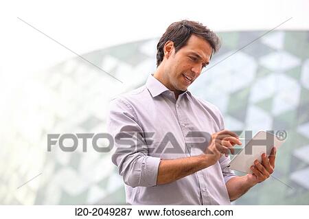 Business man with tablet in business center. San Sebastian Technology Park. Donostia. Gipuzkoa. Basque Country. Spain. View Large Photo Image Stock Photo - Business man with tablet in business center. San Sebastian Technology Park. Donostia. Gipuzkoa. Basque Country. Spain.. Fotosearch