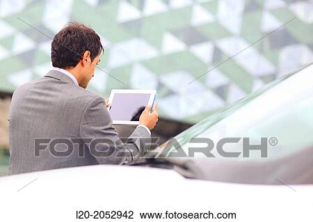Stock Image - Business man with tablet in parking business center. San Sebastian Technology Park. Donostia. Gipuzkoa. Basque Country. Spain.. Fotosearch