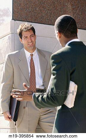 Picture - business men talking outdoors. Fotosearch