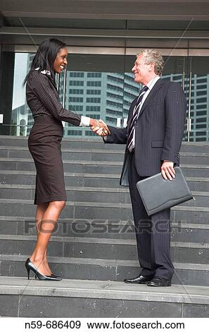 Business people shaking hands outside offices View Large Photo Image Stock Photo - Business people shaking hands outside offices. Fotosearch