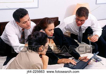Stock Image - Business people working in a hotel room. Fotosearch