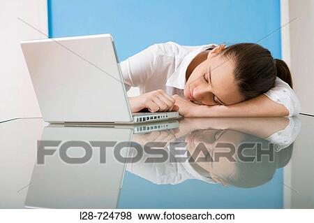 Stock Photo - business sleeping in front of laptop. Fotosearch