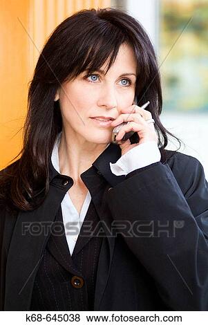 Business woman, 45, with cell phone on street View Large Photo Image Stock Photo - Business woman, 45, with cell phone on street. Fotosearch