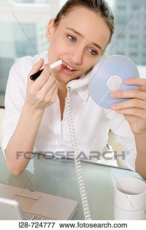 Stock Photo - business woman applying make-up. Fotosearch