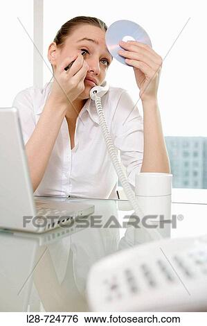 Stock Photograph - business woman applying make-up. Fotosearch
