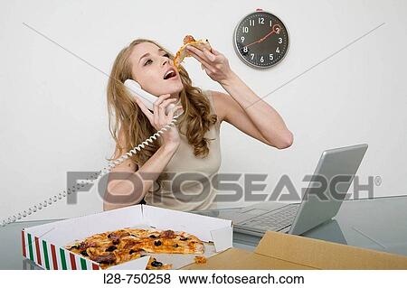 Stock Photo - business woman eating pizza and answering telephone. Fotosearch