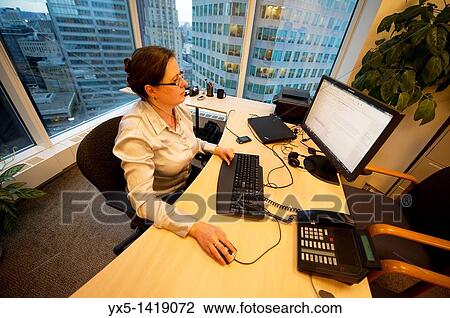 Business woman executive in a corner office sitting at the desk working on the computer View Large Photo Image Stock Image - Business woman executive in a corner office sitting at the desk working on the computer. Fotosearch