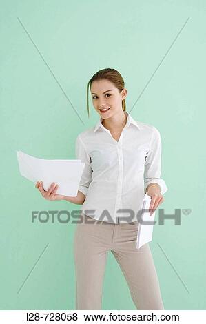 Stock Photo - business woman holding documents, smiling. Fotosearch