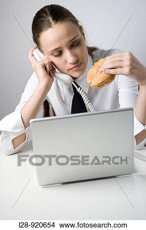 Business Woman on Phone Eating Sandwich and Working View Large Photo Image Picture - Business Woman on Phone Eating Sandwich and Working. Fotosearch