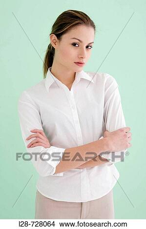 Picture - business woman standing with arm crossed. Fotosearch