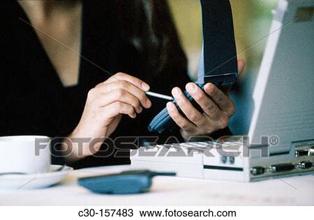 Business woman uses PDA and laptop while in restaurant View Large Photo Image Stock Image - Business woman uses PDA and laptop while in restaurant. Fotosearch