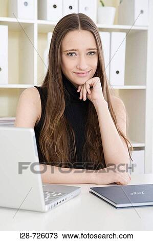 Stock Image - business woman using computer, smiling. Fotosearch