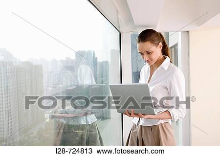 business woman using laptop near window View Large Photo Image Stock Image - business woman using laptop near window. Fotosearch