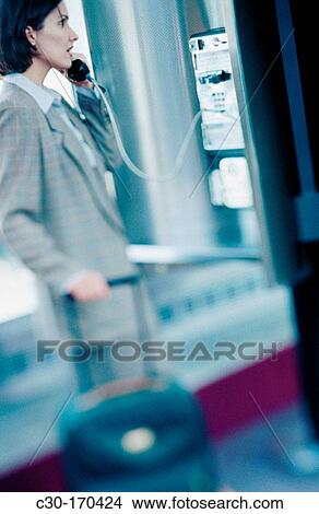 Picture - Business woman using public phone. Fotosearch