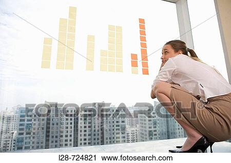 Stock Image - business woman watching sticky note. Fotosearch