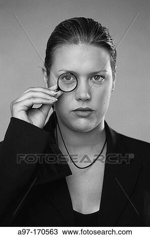 Stock Image - Business woman wearing a monocle. Fotosearch