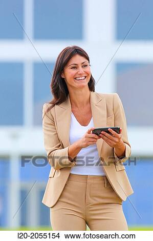 Picture - Business woman with smartphone in business center. San Sebastian Technology Park. Donostia. Gipuzkoa. Basque Country. Spain.. Fotosearch