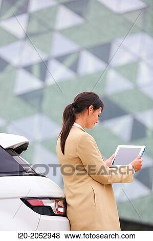 Stock Photo - Business woman with tablet in parking business center. San Sebastian Technology Park. Donostia. Gipuzkoa. Basque Country. Spain.. Fotosearch