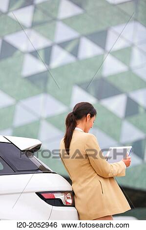 Stock Photograph - Business woman with tablet in parking business center. San Sebastian Technology Park. Donostia. Gipuzkoa. Basque Country. Spain.. Fotosearch