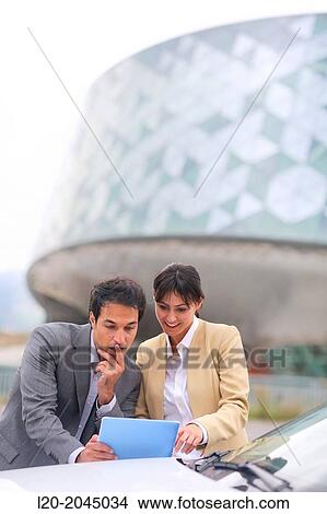 Businessman and businesswoman with tablet in parking business center. San Sebastian Technology Park. Donostia. Gipuzkoa. Basque Country. Spain. View Large Photo Image Picture - Businessman and businesswoman with tablet in parking business center. San Sebastian Technology Park. Donostia. Gipuzkoa. Basque Country. Spain.. Fotosearch