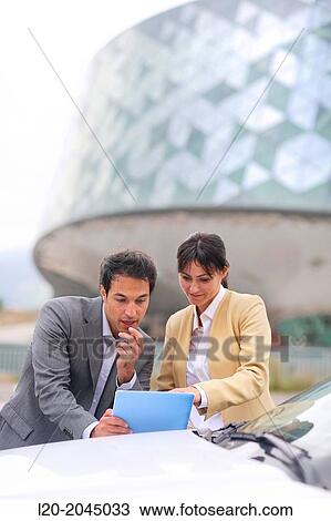 Businessman and businesswoman with tablet in parking business center. San Sebastian Technology Park. Donostia. Gipuzkoa. Basque Country. Spain. View Large Photo Image Stock Image - Businessman and businesswoman with tablet in parking business center. San Sebastian Technology Park. Donostia. Gipuzkoa. Basque Country. Spain.. Fotosearch