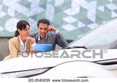 Businessman and businesswoman with tablet in parking business center. San Sebastian Technology Park. Donostia. Gipuzkoa. Basque Country. Spain. View Large Photo Image Stock Photo - Businessman and businesswoman with tablet in parking business center. San Sebastian Technology Park. Donostia. Gipuzkoa. Basque Country. Spain.. Fotosearch