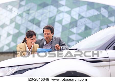 Businessman and businesswoman with tablet in parking business center. San Sebastian Technology Park. Donostia. Gipuzkoa. Basque Country. Spain. View Large Photo Image Stock Photo - Businessman and businesswoman with tablet in parking business center. San Sebastian Technology Park. Donostia. Gipuzkoa. Basque Country. Spain.. Fotosearch