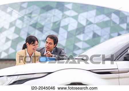 Businessman and businesswoman with tablet in parking business center. San Sebastian Technology Park. Donostia. Gipuzkoa. Basque Country. Spain. View Large Photo Image Stock Photograph - Businessman and businesswoman with tablet in parking business center. San Sebastian Technology Park. Donostia. Gipuzkoa. Basque Country. Spain.. Fotosearch