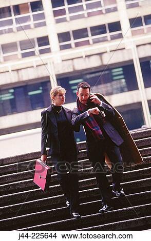 Businessman and woman walking down the stairs in the street View Large Photo Image Picture - Businessman and woman walking down the stairs in the street. Fotosearch